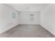 Bright, open bonus room featuring neutral carpet, white walls and ample natural light from the two windows at 11926 Verrazano Dr, Orlando, FL 32836
