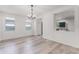 Bright dining room with wood-look floors, white walls, a modern chandelier, and natural light at 11926 Verrazano Dr, Orlando, FL 32836