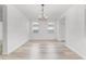Bright dining room with wood-look floors, white walls, a modern chandelier, and natural light at 11926 Verrazano Dr, Orlando, FL 32836