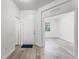 Bright entryway featuring wood-look floors, white walls, a white front door, and a glimpse into another room at 11926 Verrazano Dr, Orlando, FL 32836