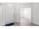 Bright entryway featuring wood-look floors, white walls, a white front door, and a glimpse into another room at 11926 Verrazano Dr, Orlando, FL 32836