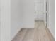 Bright hallway with sleek and modern floors, white walls, and a white door at the end at 11926 Verrazano Dr, Orlando, FL 32836