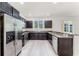 This kitchen has stainless steel appliances, dark wood cabinets, and granite countertops for a modern, attractive space at 11926 Verrazano Dr, Orlando, FL 32836