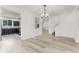 Open-concept living room with light wood floors, a decorative chandelier, and an easy pass-through to the kitchen at 11926 Verrazano Dr, Orlando, FL 32836
