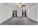 Spacious main bedroom featuring neutral carpet, white walls, a stylish ceiling fan, and two bright windows at 11926 Verrazano Dr, Orlando, FL 32836