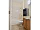 Bright bathroom featuring a shower over tub, wooden vanity, and tiled floors at 12863 Holdenbury Ln, Windermere, FL 34786