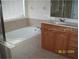 Relaxing bathroom featuring a soaking tub, a tiled surround, and a vanity with storage at 12863 Holdenbury Ln, Windermere, FL 34786