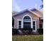 Charming home exterior featuring a large arch window, trimmed bushes, and well-maintained lawn at 12863 Holdenbury Ln, Windermere, FL 34786