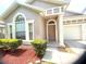 Close-up of the home's entrance, showcasing the front door, sidelight window, and manicured shrubbery at 12863 Holdenbury Ln, Windermere, FL 34786