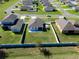 Aerial view of a residential neighborhood, showcasing a home with a fenced backyard and well-kept landscaping at 13233 Lake Yale View Loop, Grand Island, FL 32735