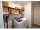 A well-organized laundry room with wooden shelving, storage baskets, and a modern washer and dryer at 13233 Lake Yale View Loop, Grand Island, FL 32735