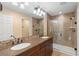 Bathroom with a double sink vanity, large mirror, walk-in shower, and tile accents at 1341 Mill Stream Ln, Winter Springs, FL 32708