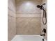 Bathtub with beige tile surround, a shower head, and a decorative accent tile at 1341 Mill Stream Ln, Winter Springs, FL 32708
