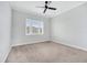 Bedroom featuring neutral carpet, a ceiling fan, and large window, offering a relaxing space at 13852 Maskawa Ave, Orlando, FL 32827