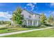 A bright and sunny two-story home with a covered porch and nicely trimmed landscaping at 13852 Maskawa Ave, Orlando, FL 32827