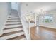 Bright and spacious living room featuring hardwood floors, a modern chandelier, and staircase at 13852 Maskawa Ave, Orlando, FL 32827