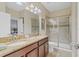 Bathroom with a double vanity, granite countertops, and glass shower at 1400 Moon Valley Dr, Davenport, FL 33896