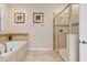 Bright bathroom featuring a soaking tub and glass enclosed shower with neutral tile at 1400 Moon Valley Dr, Davenport, FL 33896