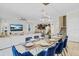 Elegant dining room area with seating for eight, modern lighting, and an open view to the living area at 1400 Moon Valley Dr, Davenport, FL 33896