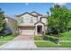 Charming two-story home featuring a well-manicured lawn, stone accents, and a two-car garage at 1400 Moon Valley Dr, Davenport, FL 33896