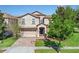Charming two-story home featuring a brick driveway, two-car garage, and well-manicured landscaping at 1400 Moon Valley Dr, Davenport, FL 33896