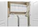 Convenient laundry room featuring a washer, dryer, and overhead storage cabinets at 1400 Moon Valley Dr, Davenport, FL 33896
