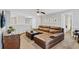 Spacious living room with brown leather sofa, ceiling fan, and a view into other rooms at 1400 Moon Valley Dr, Davenport, FL 33896