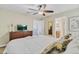 Bright main bedroom with a ceiling fan, dresser, and view into the bathroom at 1400 Moon Valley Dr, Davenport, FL 33896