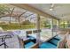 Enclosed patio area with dining table, cushioned chairs, ceiling fan, and view of the swimming pool at 1400 Moon Valley Dr, Davenport, FL 33896