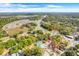 Aerial view showcases a wooded lot bordered in red, nestled in a community with parks and easy access to a highway at 15 E Mohawk Street, Mascotte, FL 34753