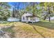 Exterior side view of a cozy home featuring a mature trees at 15 E Mohawk Street, Mascotte, FL 34753