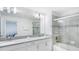 Modern bathroom features double sinks with shower and tub behind glass door at 1563 Sandbagger Dr, Davenport, FL 33896