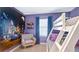 This bedroom has a fun space themed mural with a bunk bed and a comfy chair at 1563 Sandbagger Dr, Davenport, FL 33896