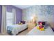 Charming bedroom featuring comic themed wallpaper and twin beds at 1563 Sandbagger Dr, Davenport, FL 33896