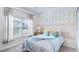 This bedroom has an accent wall, a plush bed, and a sunlit window at 1563 Sandbagger Dr, Davenport, FL 33896