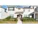 Charming two-story townhome featuring lush landscaping and a welcoming entryway at 1563 Sandbagger Dr, Davenport, FL 33896