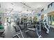 Bright gym with ceiling fan, several windows, various workout machines, and plenty of floor space at 1563 Sandbagger Dr, Davenport, FL 33896