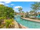 Outdoor lazy river surrounded by tropical landscaping and a wooden bridge at 1563 Sandbagger Dr, Davenport, FL 33896