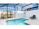 Covered pool offers refreshing retreat with comfortable lounge chairs and patio at 1563 Sandbagger Dr, Davenport, FL 33896