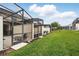 Row of screened-in patios with a view of a lush green lawn and landscaping surrounding the vacation property at 1570 Sandbagger Dr, Davenport, FL 33896