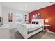 Cozy bedroom with red accent wall, featuring comfortable bed, fun Disney decor, and soft natural light at 1570 Sandbagger Dr, Davenport, FL 33896