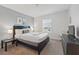 Bright bedroom featuring a cozy bed, modern decor, and soft natural light from the large window at 1570 Sandbagger Dr, Davenport, FL 33896