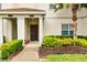 Close-up of a townhouse entrance showing a walkway, shrubs, and a covered entryway at 1570 Sandbagger Dr, Davenport, FL 33896