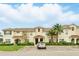 Inviting townhouse featuring a tile roof, lush landscaping, and convenient parking spaces at 1570 Sandbagger Dr, Davenport, FL 33896