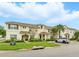 Exterior of a stucco townhouse with tile roof, green grass, shrubs, and a parked car at 1570 Sandbagger Dr, Davenport, FL 33896