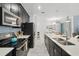 Modern kitchen featuring stainless steel appliances, dark cabinets, and a large island with a sink at 1570 Sandbagger Dr, Davenport, FL 33896
