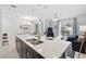 Bright kitchen island with white countertop, pendant lighting, and stainless steel sink with a view to the pool area at 1570 Sandbagger Dr, Davenport, FL 33896