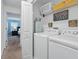 Efficient laundry room with washer, dryer, shelving, storage and access to a nearby bedroom at 1570 Sandbagger Dr, Davenport, FL 33896