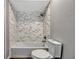 Bathroom view highlighting the bathtub, shower with decorative tile, and low flow toilet at 188 Citrus Dr, Kissimmee, FL 34743
