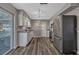 Bright kitchen with stainless steel appliances, white cabinets, vinyl flooring and access to the porch at 188 Citrus Dr, Kissimmee, FL 34743